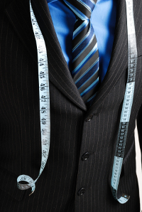 This is an image of business man wearing a tape measure across his suit.